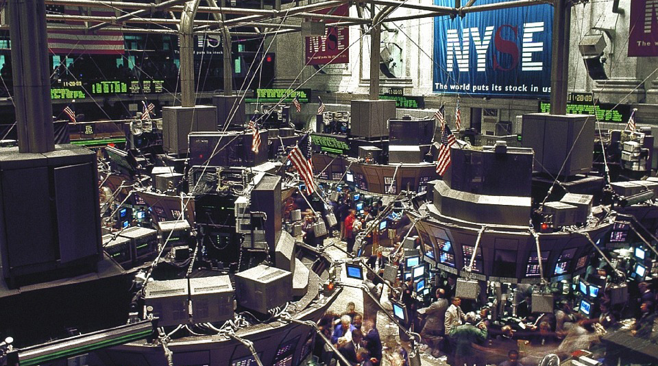 Bolsa de Valores de Nueva York, corredores de bolsa frente a monitores y pantallas que muestran las variaciones dentro del mercado.