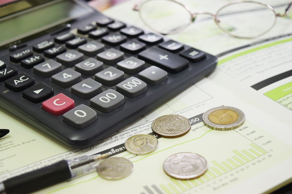 Fotografía de evaluación de proyectos financieros, con gráficas,  calculadora, dinero.